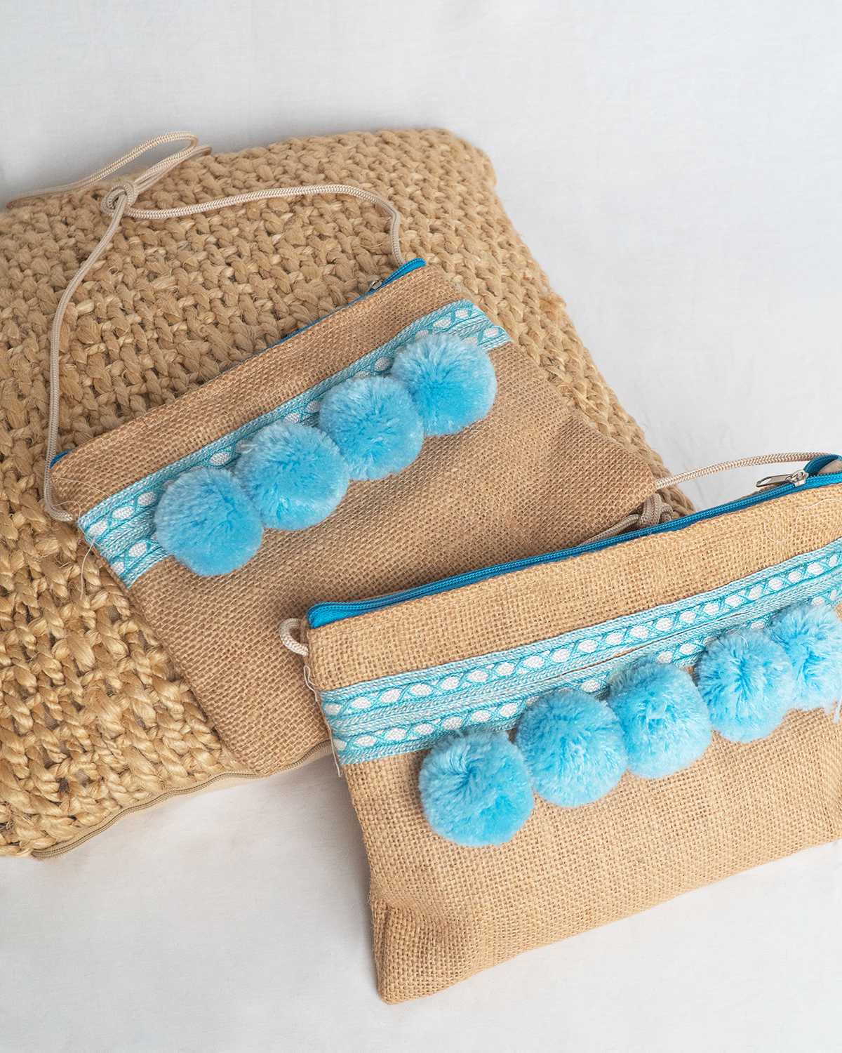 Bolso artesanal con pompones turquesa y cinta de seda.