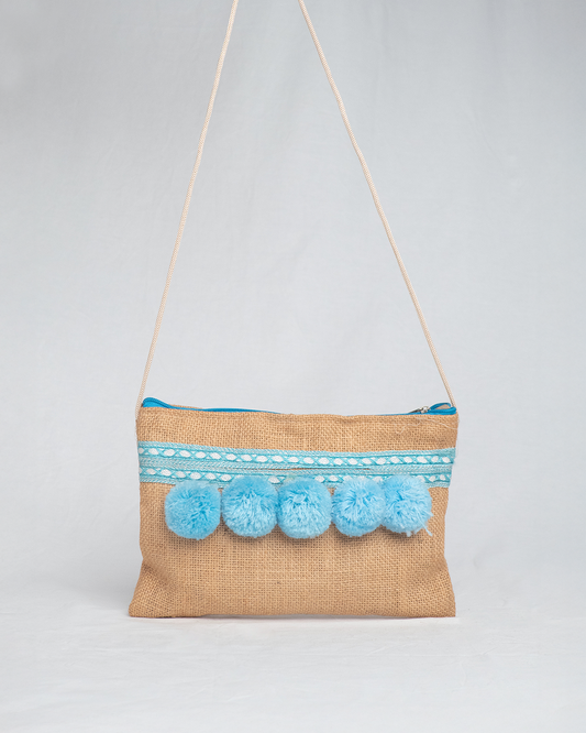 Bolso artesanal con pompones turquesa y cinta de seda.